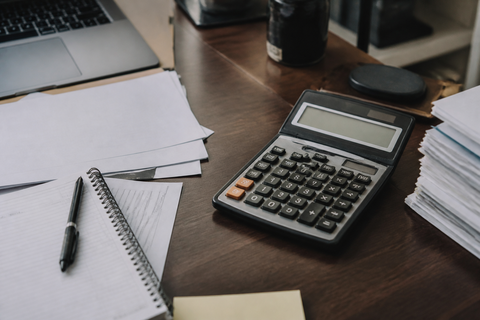 Calculatrice affichant chiffres et formules commerciales sur bureau.