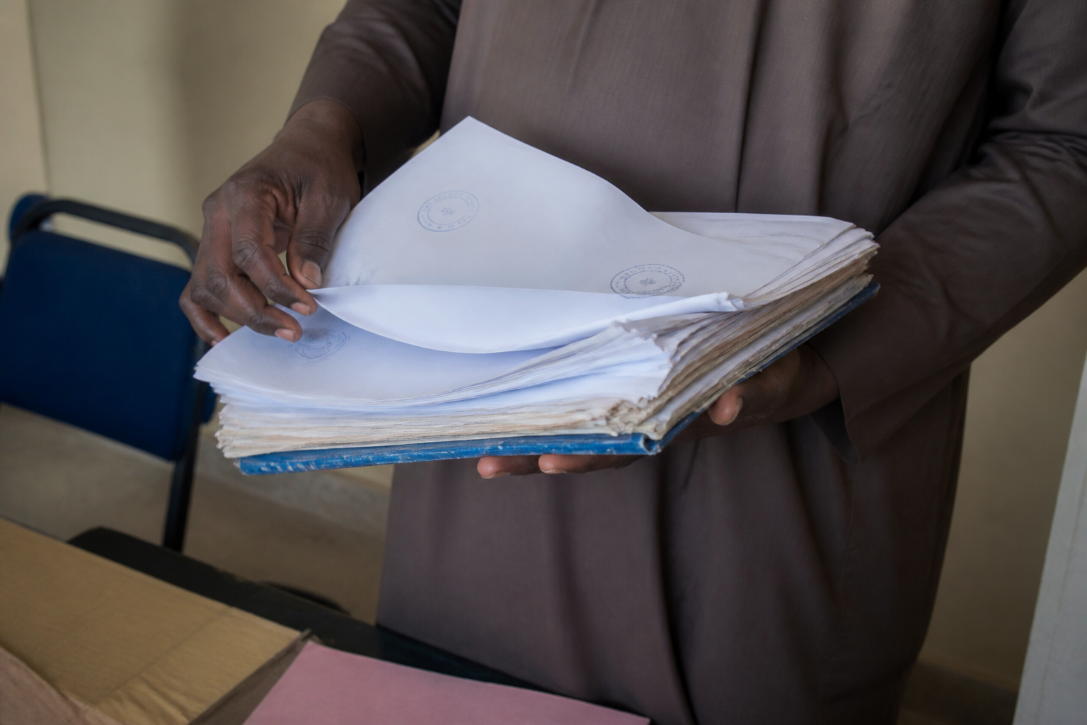 Mains tenant documents papier avec tampons officiels.